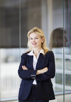 Portrait of a blonde woman smiling in a business suit.
